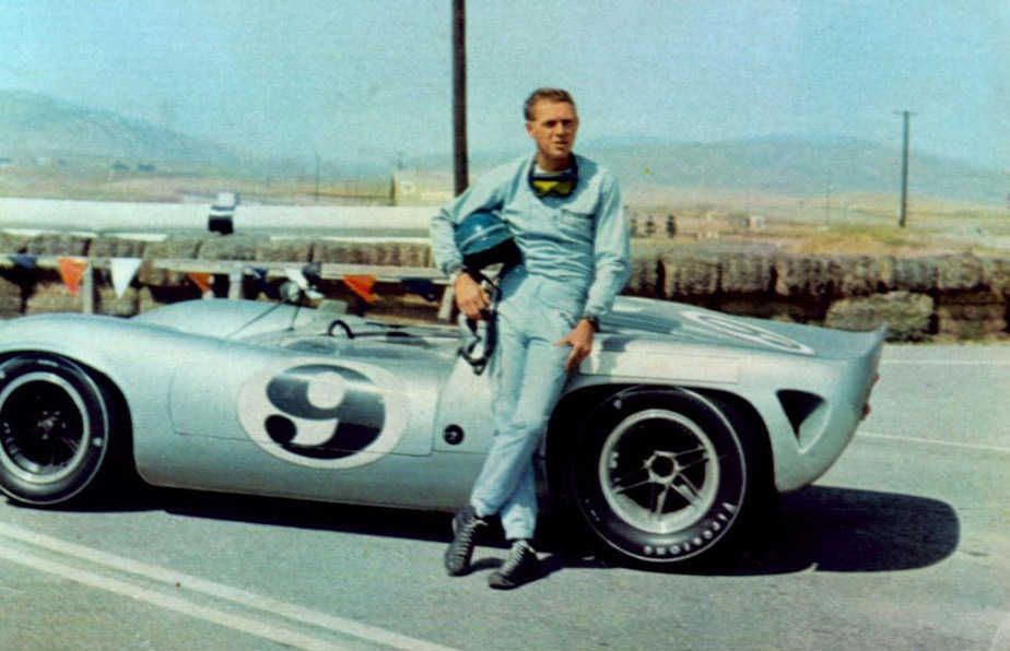 Hollywood legend Steve McQueen posing infront of race car